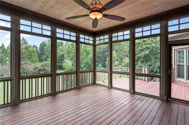 unfurnished sunroom with ceiling fan, plenty of natural light, and wooden ceiling