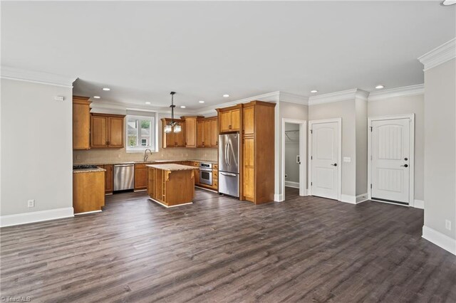 kitchen with a center island, dark wood-type flooring, sink, hanging light fixtures, and appliances with stainless steel finishes