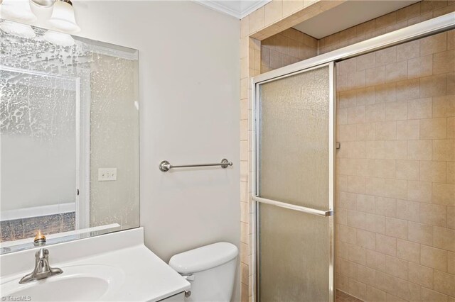 bathroom featuring an enclosed shower, crown molding, vanity, and toilet