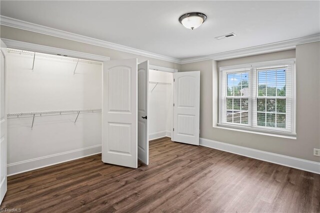 unfurnished bedroom featuring dark wood-type flooring and ornamental molding