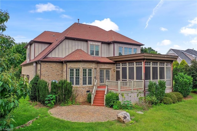 back of house with a yard and a sunroom