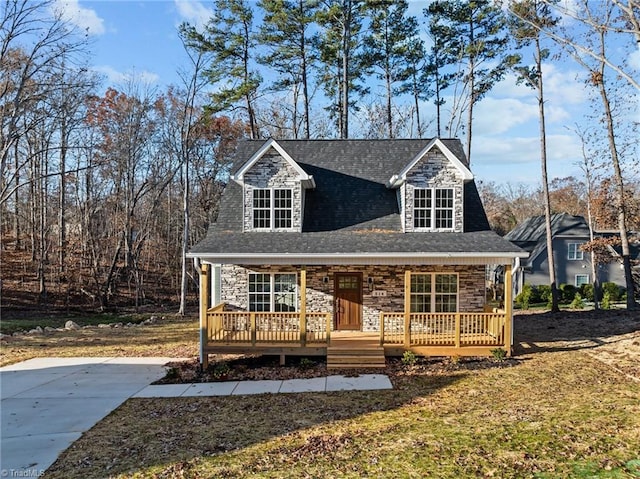 view of front of house featuring stone siding, roof with shingles, and a porch