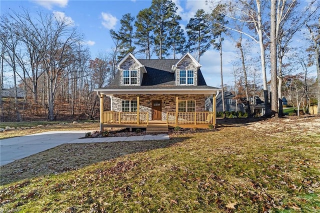 view of front facade featuring stone siding, a porch, and a front lawn