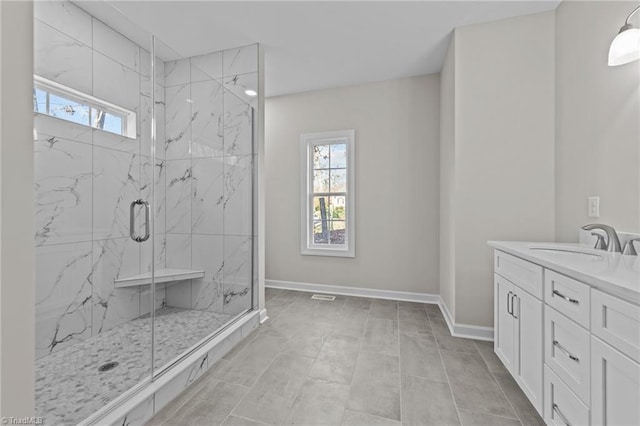 bathroom featuring vanity, baseboards, and a marble finish shower