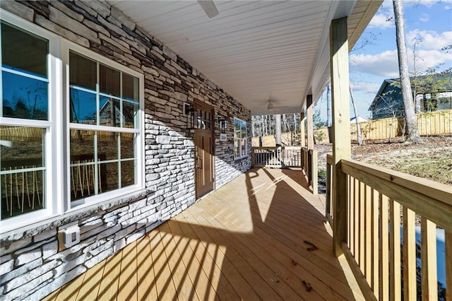 wooden terrace with a porch and a ceiling fan