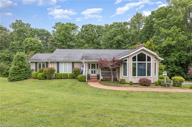 view of front of property with a front lawn, covered porch, a chimney, and board and batten siding