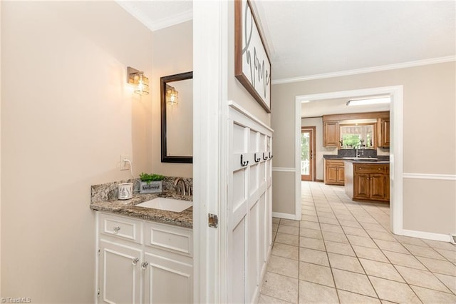 bathroom with baseboards, vanity, tile patterned floors, and crown molding
