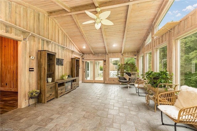 sunroom featuring wood ceiling, stone tile flooring, and wood walls