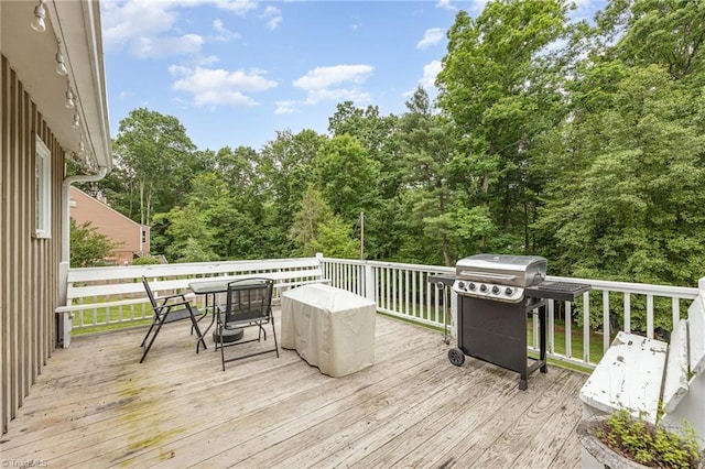 wooden deck with a grill and outdoor dining space