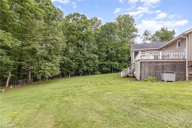 view of green lawn featuring cooling unit, stairs, and a deck
