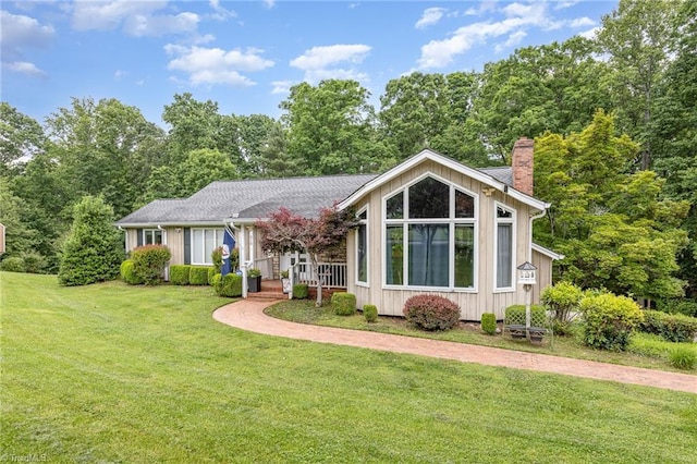 view of front of home featuring a chimney, a front yard, and a porch