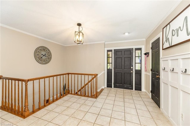 entryway with crown molding, a chandelier, and light tile patterned floors