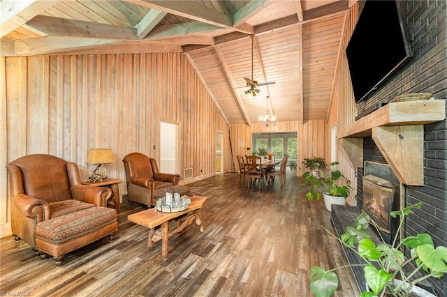 sitting room featuring hardwood / wood-style flooring, wooden walls, a chandelier, a brick fireplace, and wood ceiling