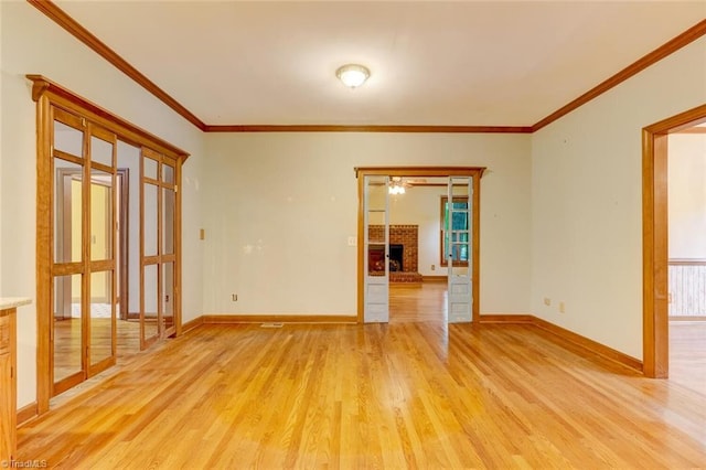 6400 Muirfield Dr, Greensboro, NC 27410 - empty room with light wood-style flooring, a fireplace, crown molding, and ceiling fan
