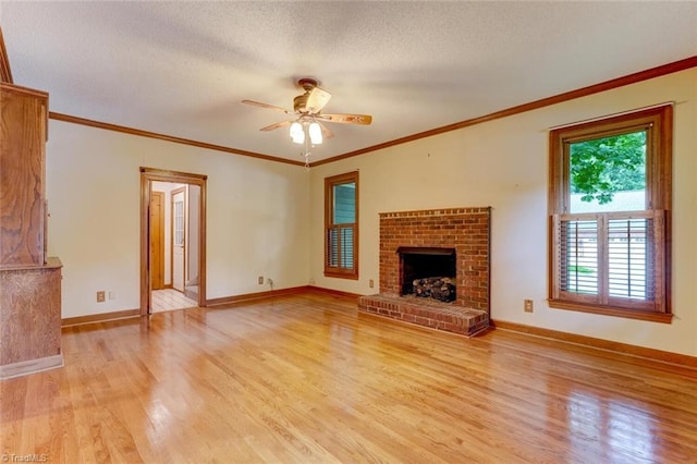 6400 Muirfield Dr, Greensboro, NC 27410 - unfurnished living room featuring light wood-style flooring, ceiling fan, a brick fireplace, ornamental molding, and a textured ceiling