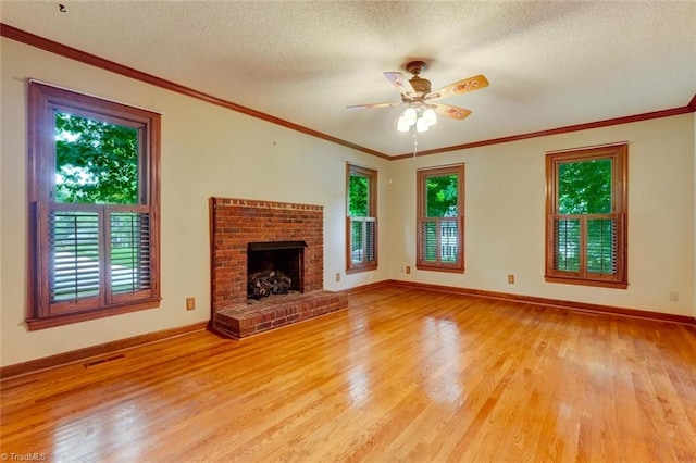 6400 Muirfield Dr, Greensboro, NC 27410 - unfurnished living room with light wood-style floors, ceiling fan, a textured ceiling, a brick fireplace, and ornamental molding