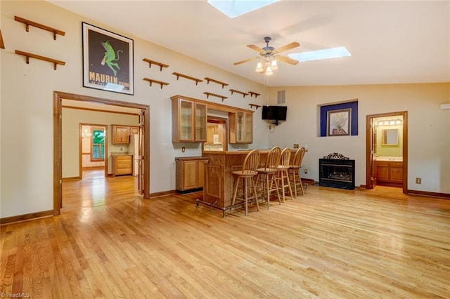 6400 Muirfield Dr, Greensboro, NC 27410 - indoor bar featuring a skylight, light wood-style floors, a ceiling fan, and a fireplace