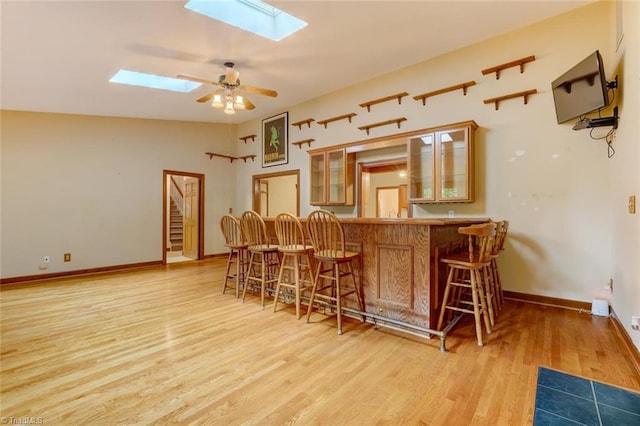 6400 Muirfield Dr, Greensboro, NC 27410 - indoor bar with a skylight, light wood-style flooring, ceiling fan, and stairway