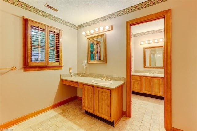 6400 Muirfield Dr, Greensboro, NC 27410 - bathroom featuring two vanities and a textured ceiling