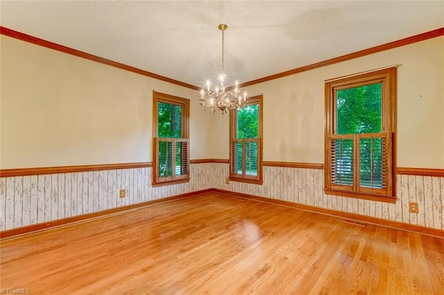 6400 Muirfield Dr, Greensboro, NC 27410 - spare room with wood finished floors, a chandelier, a wainscoted wall, and ornamental molding