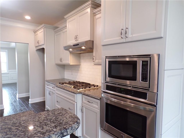 8003 Helison Ct, Stokesdale, NC 27357 - kitchen with ornamental molding, dark wood-type flooring, under cabinet range hood, decorative backsplash, and appliances with stainless steel finishes