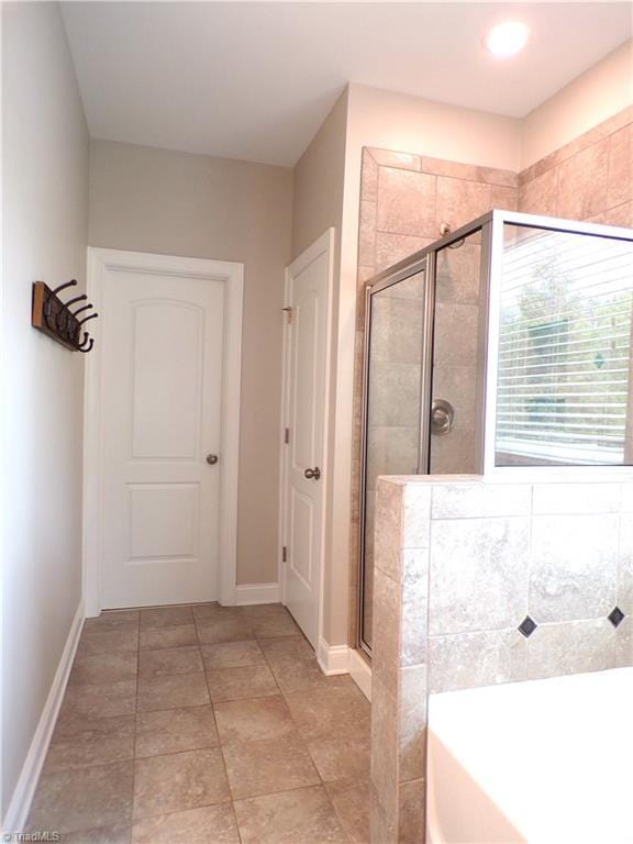 8003 Helison Ct, Stokesdale, NC 27357 - bathroom with a bath, baseboards, a stall shower, and tile patterned flooring