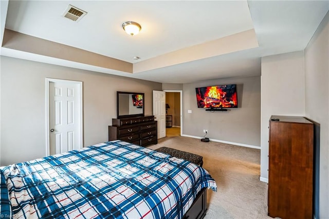 bedroom featuring light carpet and a tray ceiling