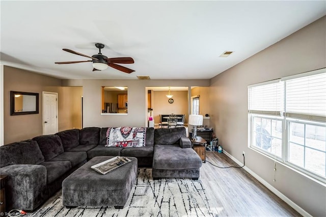 living room featuring ceiling fan, a healthy amount of sunlight, and light wood-type flooring