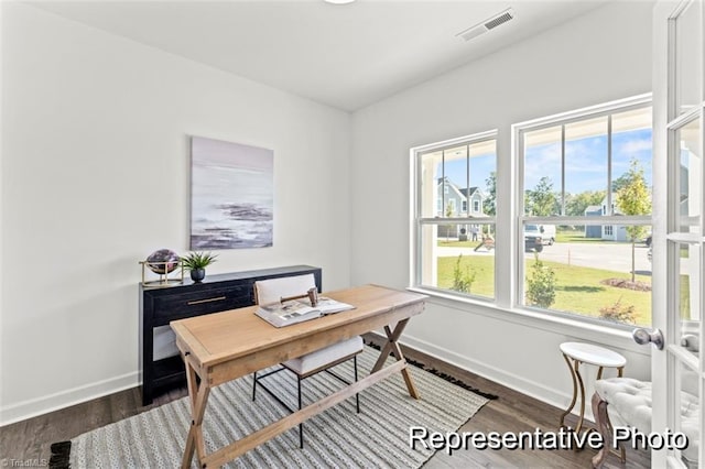 office space featuring visible vents, baseboards, and wood finished floors