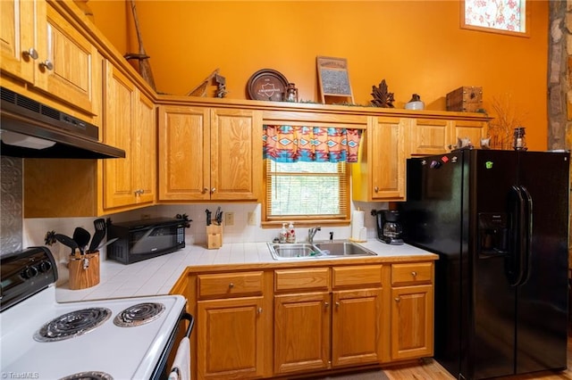 kitchen with sink, tile countertops, exhaust hood, white electric stove, and black refrigerator with ice dispenser