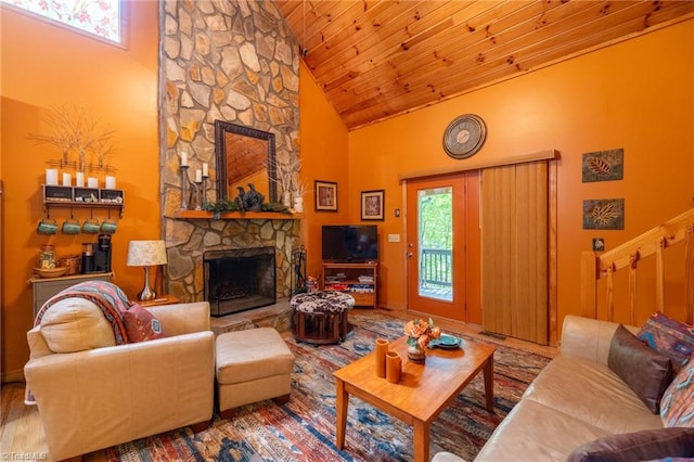 living room with a stone fireplace, hardwood / wood-style flooring, plenty of natural light, and high vaulted ceiling