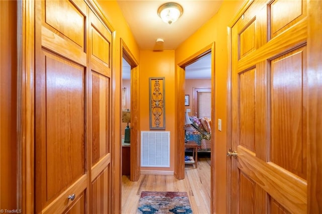 hallway with light hardwood / wood-style floors