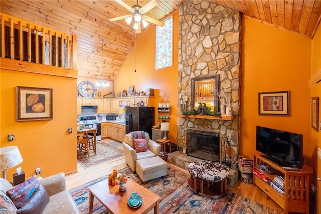 living room with high vaulted ceiling, a stone fireplace, wooden ceiling, light hardwood / wood-style flooring, and ceiling fan