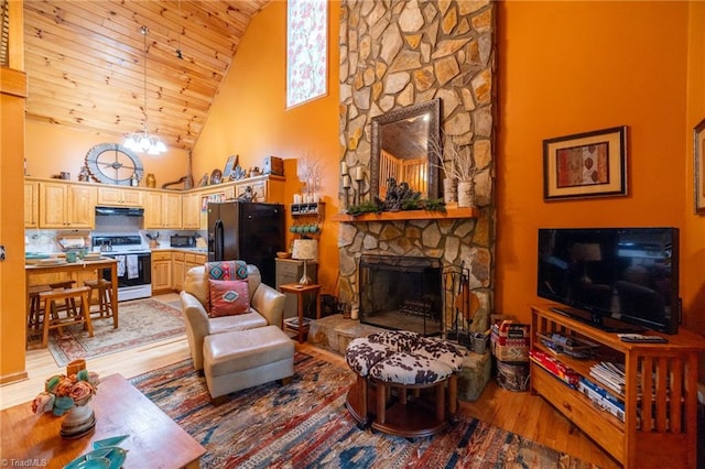 living room featuring light wood-type flooring, wood ceiling, high vaulted ceiling, a notable chandelier, and a fireplace