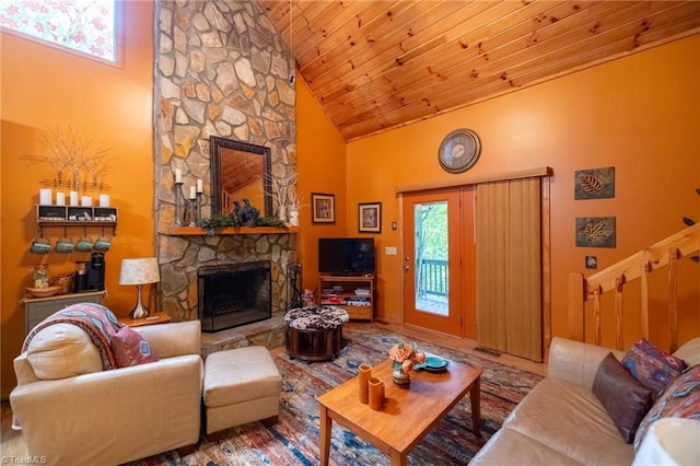 living room featuring wood ceiling, a stone fireplace, high vaulted ceiling, and a wealth of natural light