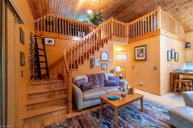 living room with a high ceiling, wood ceiling, and hardwood / wood-style floors