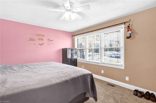 bedroom featuring ceiling fan, carpet, and a textured ceiling