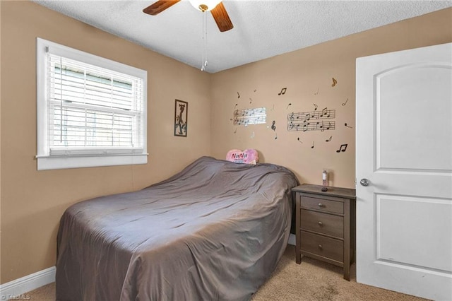 carpeted bedroom with ceiling fan and a textured ceiling