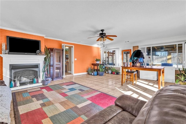 living room featuring tile patterned floors, crown molding, ceiling fan, and a healthy amount of sunlight