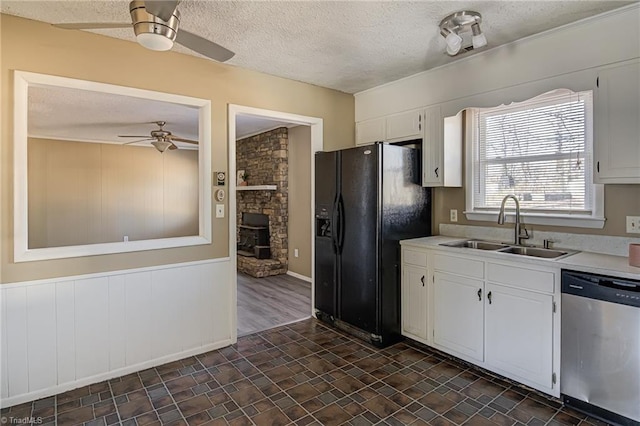 kitchen featuring white cabinets, black fridge with ice dispenser, ceiling fan, sink, and dishwasher