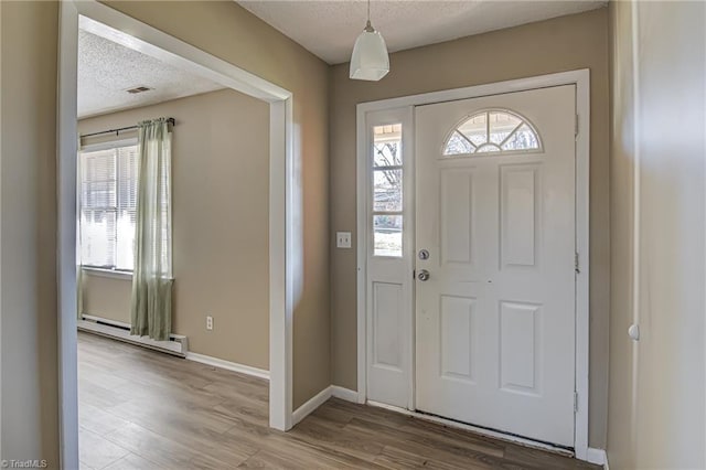 foyer entrance featuring a baseboard radiator, a textured ceiling, and hardwood / wood-style flooring