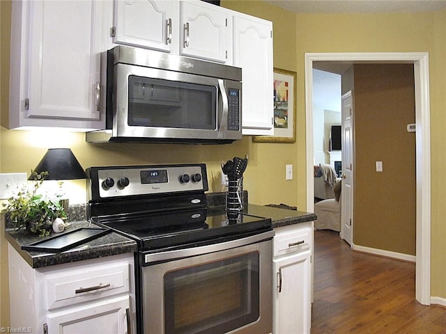 kitchen with white cabinets, dark wood-style floors, baseboards, and stainless steel appliances