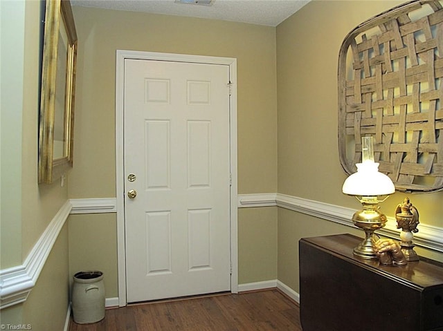 entryway featuring visible vents, baseboards, and dark wood-style flooring