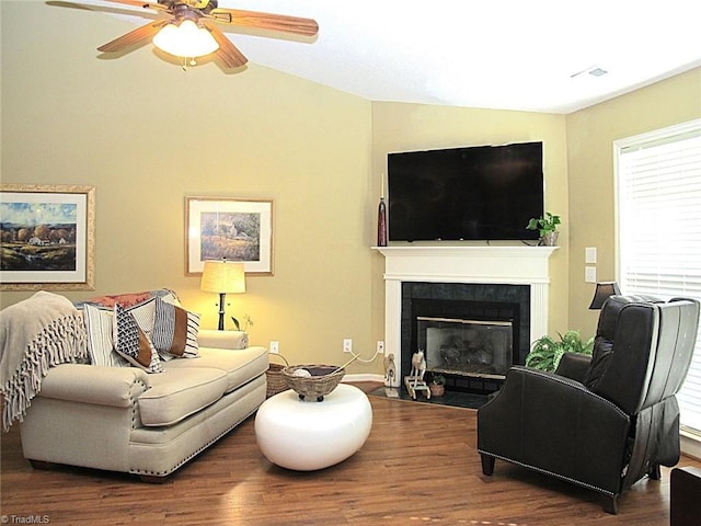 living area with wood finished floors, ceiling fan, and a tile fireplace