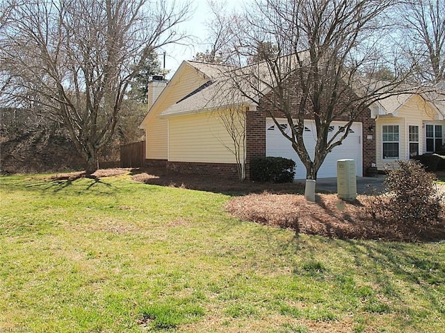 view of side of property featuring a lawn, an attached garage, and a chimney