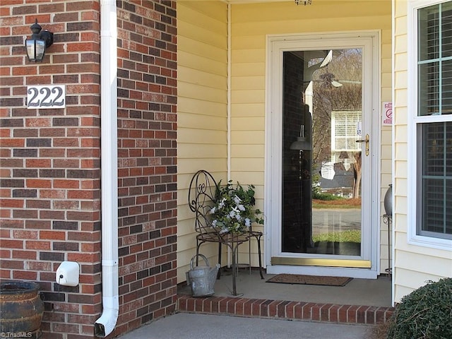 view of exterior entry featuring brick siding