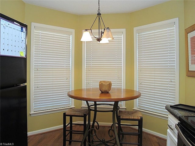 dining space with dark wood-style floors, baseboards, and a chandelier