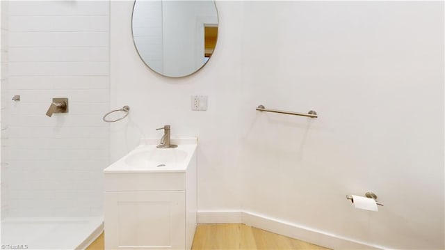 bathroom with a shower, vanity, and hardwood / wood-style flooring