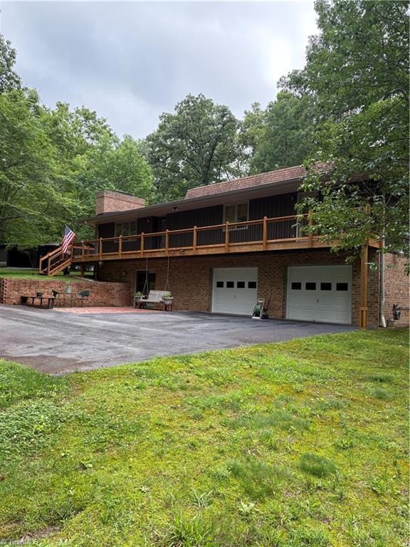 235 Hogan Bowers Rd, Thomasville, NC 27360 - view of front of property with asphalt driveway, a front lawn, an attached garage, and brick siding