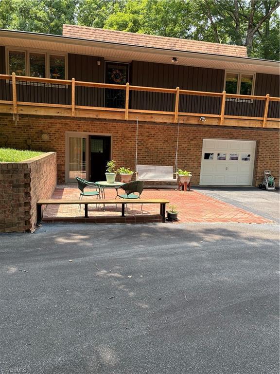235 Hogan Bowers Rd, Thomasville, NC 27360 - view of front of property featuring a garage, brick siding, board and batten siding, and driveway